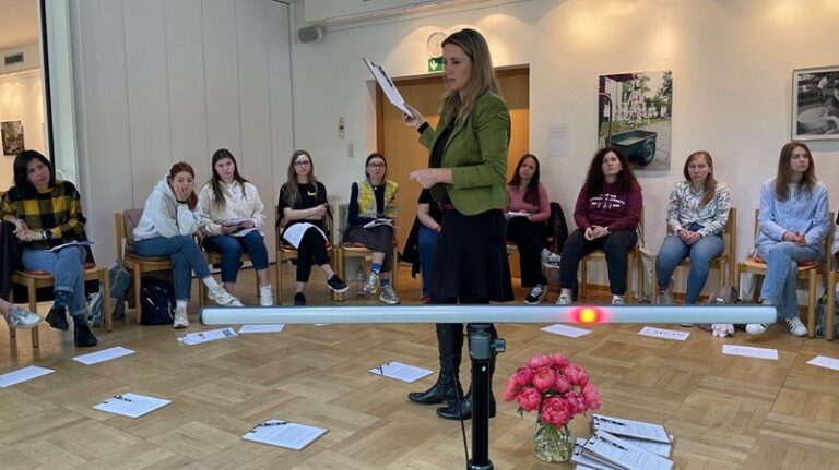 Teilnehmerinnen des Trauma-Seminars sitzen im Kreis, vorne eine Referentin